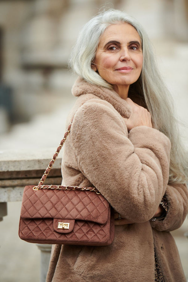 Woman in Mink Faux Fur Coat with tan handbag